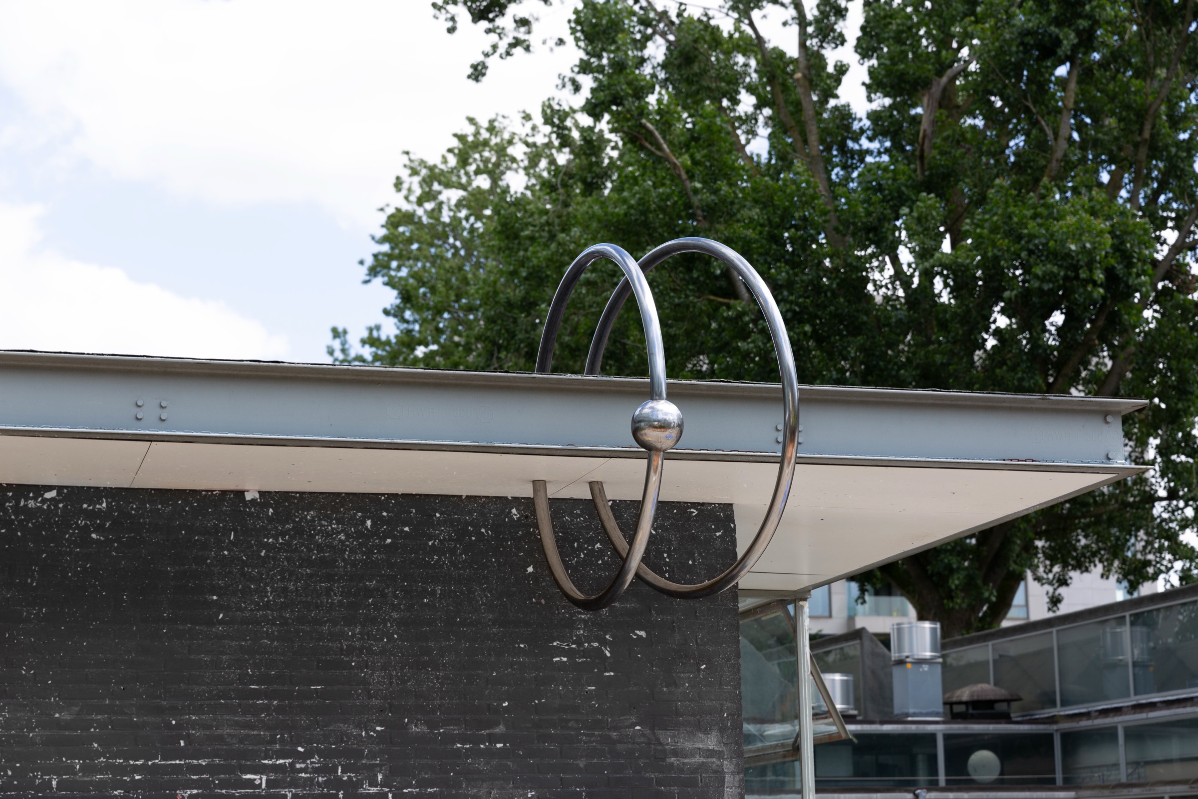 Two large steel rings with a ball closure hooked through the roof edge of the Gerrit Rietveld Pavilion.